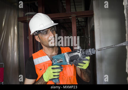 Construction worker working with hammer drill Stock Photo