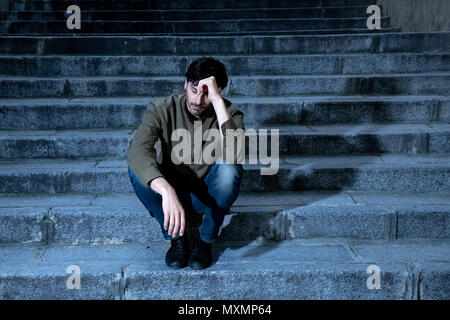 latin man stressed from work sitting on steps outside feeling anxiety in adult cause of depression and problem in living that makes you feel lonely, s Stock Photo