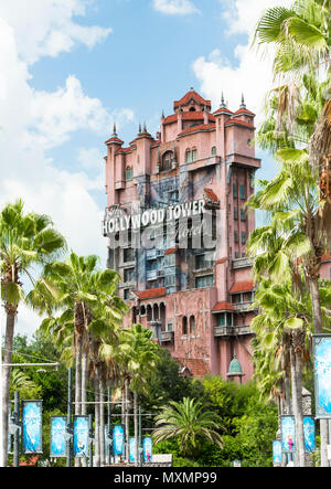 Hollywood Tower in Disney Hollywood Studios in Orlando Florida. This shot is framed by an avenue of green palm trees, blue sky and fluffy white clouds Stock Photo