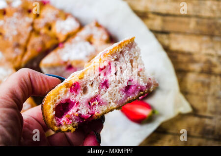 Hand holding homemade strawberry fruit pastry closeup Stock Photo