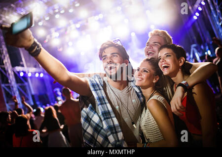 Happy friends taking selfie at music festival Stock Photo