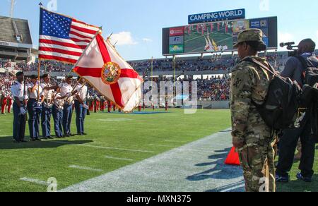An Army noncommissioned officer from the 143d Sustainment Command (Expeditionary) renders a salute during the national anthem inside Camping World Stadium, Orlando, Florida, on Nov. 19, 2016. Soldiers from active and Reserve units participating in the Florida Classic HBCU rivalry between Bethune-Cookman University and Florida A&M University engaged with thousands of fans through interactive exhibits and pre-game activities, promoting Army recruitment, career awareness, fitness, team-building, and community engagement. Stock Photo