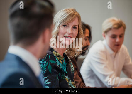 Over the shoulder, point of view shot of a business woman looking towards a business man and talking. Stock Photo