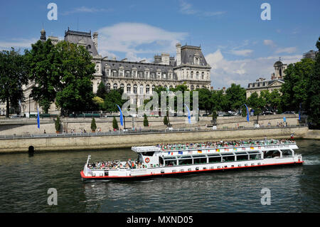 Paris (France): barge transporting tourists on the Seine River, with the City Hall in the background and the 'Pont d'Arcole' bridge in the foreground, Stock Photo