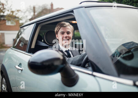 Front view of a young businessman looking at the camera while in a car. Morning commute to work. Stock Photo