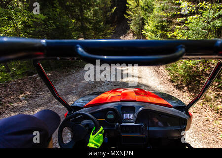 Young people on UTV vehicles on a countryside trail. View from a UTV vehicle with man driving an UTV on a sunny day. Stock Photo