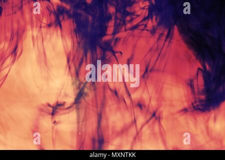 Blue ink color in red water. Useful for texture or background. Stock Photo