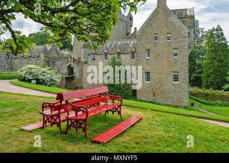 CAWDOR CASTLE NAIRN SCOTLAND RED BENCH UNDER A TREE IN FRONT OF THE BUILDING Stock Photo