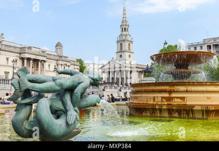 Mermaid statue in the fountains at Trafalgar Square, Westminster, central London WC2 St Martin in the Fields church and the National Gallery behind Stock Photo