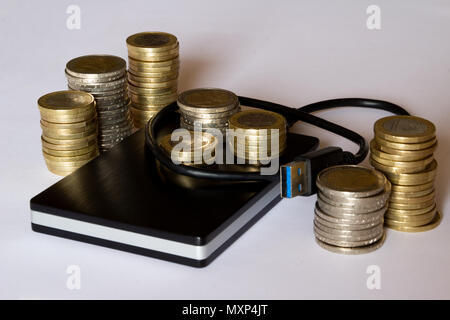 External hard drive with money stacked on top Stock Photo