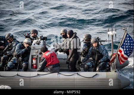 161117-N-UF697-074 SEA OF JAPAN (Nov. 17, 2016) Sailors assigned to the forward-deployed Arleigh Burke-class guided-missile destroyer USS Barry (DDG 52) visit, board, search and seizure (VBSS) team approach the ship in a rigid-hull inflatable boat (RHIB) during a training exercise. Barry is on patrol in the U.S. 7th Fleet area of operations supporting security and stability in the Indo-Asia-Pacific region. (U.S. Navy photo by Petty Officer 2nd Class Kevin V. Cunningham/Released) Stock Photo