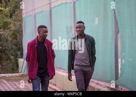 Two black race friends walking in the street. Friends Concept Stock Photo