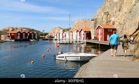 Smogen, Sweden - May 19, 2018: Travel documentary of everyday life and place. People walking along the pier enjoying the sunshine and the view of boat Stock Photo