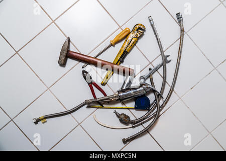 specialist male plumber repairs faucet in kitchen Stock Photo