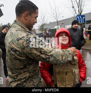 A U.S. Marine helps out a Lithuanian boy try on military protective gear at a static display in Visaginas, Lithuania, Nov. 26, 2016. Militaries from several countries taking part in Exercise Iron Sword 16, including United States, Lithuania, United Kingdom, Poland, Luxembourg, Latvia, and Canada interacted with and demonstrated their gear to locals and other visitors. Black Sea Rotational Force is an annual multilateral security cooperation activity between the U.S. Marine Corps and partner nations in the Black Sea, Balkan and Caucasus regions designed to enhance participants’ collective profe Stock Photo