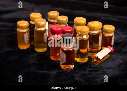 Numerous bottles of magical potion on dark background Stock Photo