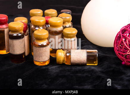 Magic potion in a small bottle closeup on black background Stock Photo