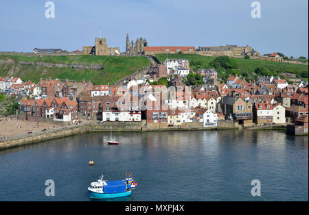 Whitby harbour and the River Esk with St Marys Church and Whitby Abbey on the hilltop Stock Photo