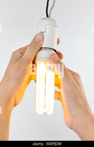 hands replacing energy saving light bulb, closeup Stock Photo