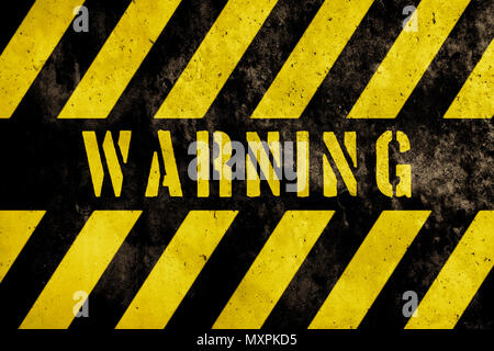 Warning sign text with yellow and dark stripes painted over concrete wall facade texture background. Concept image for caution, danger and hazard. Stock Photo