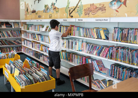 UK,Surrey,UK- 10 years schoolboy choosing books in public library Stock Photo