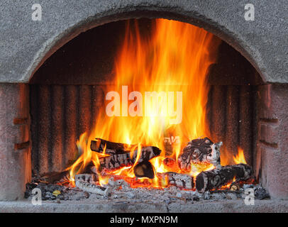 Fireplace with fire at night - outdoor shot Stock Photo