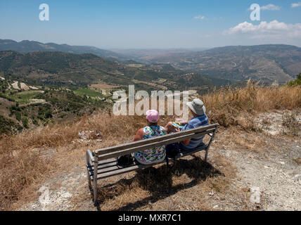 A couple enjoy the view overlooking a terraced hillside in the Troodos mountain range,  Paphos region of Cyprus. Stock Photo