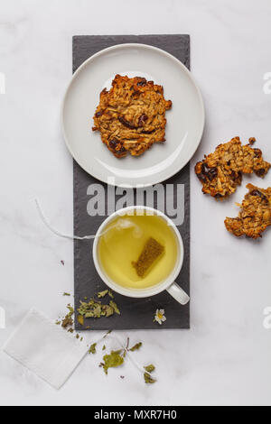 Green (herbal, white) tea with cookies on white background. Flat lay food, breakfast lifeslyle concept Stock Photo