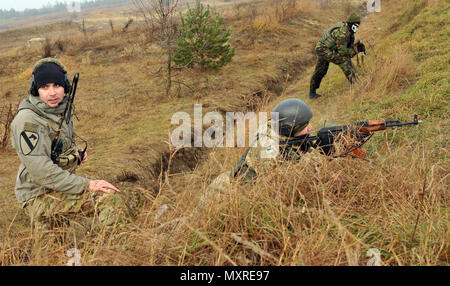 Sgt. Christopher Marinucci, assistant team leader assigned to 6th Squadron, 8th Cavalry Regiment, 2nd Infantry Brigade Combat Team, 3rd Infantry Division observes a Ukrainian Soldier during an air assault mission in conjunction with a situational training exercise with Ukrainian Soldiers assigned to 1st Battalion, 80th Airmobile Brigade, at the International Peacekeeping and Security Center in Yavoriv, Ukraine, Nov. 26, 2016. The Joint Multinational Training Group-Ukraine provides U.S. Soldiers and Special Operations personnel to train Ukraine National Guard units in an ongoing effort to stren Stock Photo