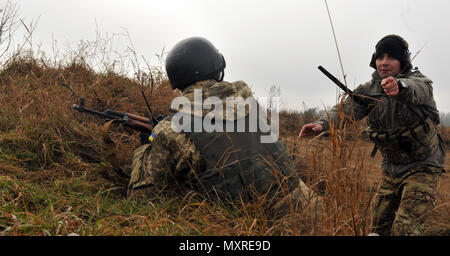 Sgt. Christopher Marinucci, assistant team leader assigned to 6th Squadron, 8th Cavalry Regiment, 2nd Infantry Brigade Combat Team, 3rd Infantry Division points to an objective during an air assault mission in conjunction with a situational training exercise with Ukrainian Soldiers assigned to 1st Battalion, 80th Airmobile Brigade, at the International Peacekeeping and Security Center in Yavoriv, Ukraine, Nov. 26, 2016. The Joint Multinational Training Group-Ukraine provides U.S. Soldiers and Special Operations personnel to train Ukraine National Guard units in an ongoing effort to strengthen  Stock Photo