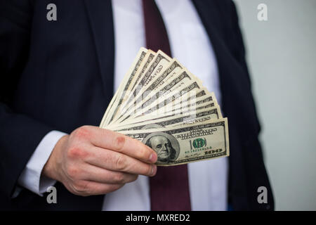 Business Man Displaying a Spread of Cash over a white vintage background Stock Photo