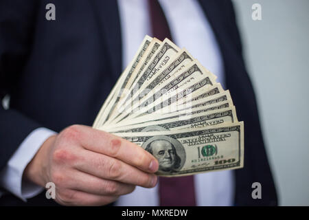 Business Man Displaying a Spread of Cash over a white vintage background Stock Photo