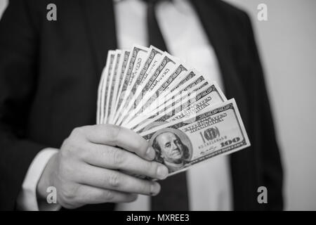 Business Man Displaying a Spread of Cash over a white vintage background Stock Photo