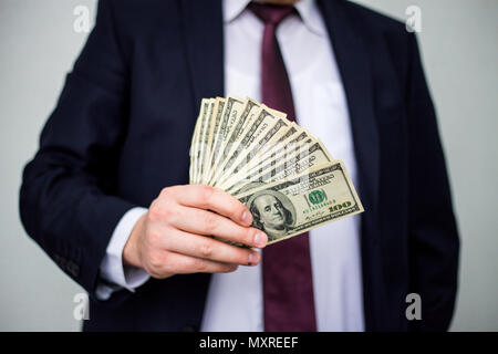 Business Man Displaying a Spread of Cash over a white vintage background Stock Photo