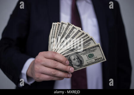 Business Man Displaying a Spread of Cash over a white vintage background Stock Photo