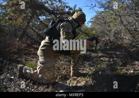 WESTHAMPTON BEACH, NY - Senior Airman Alexander Traini, a Survival, Evasion, Resistance and Escape (SERE) Specialist with the 106th Rescue Wing conducts a personnel recovery training mission  at F.S. Gabreski Air National Guard Base on December 4th, 2016.    During the training mission, nn HH-60 Pavehawk with the 101st Rescue Squadron and Pararescue Jumpers with the 103rd Rescue Squadron searched for Triani, who portrated a downed F-16 Pilot.    (US Air National Guard / Staff Sergeant Christopher S. Muncy / released) Stock Photo