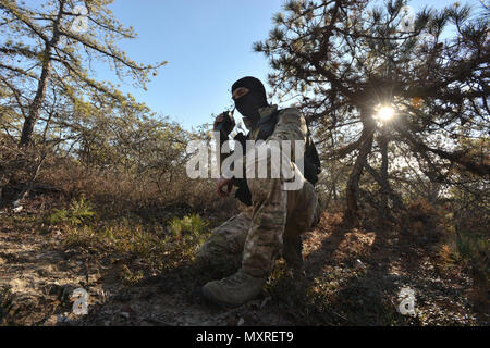 WESTHAMPTON BEACH, NY - Senior Airman Alexander Traini, a Survival, Evasion, Resistance and Escape (SERE) Specialist with the 106th Rescue Wing conducts a personnel recovery training mission  at F.S. Gabreski Air National Guard Base on December 4th, 2016.    During the training mission, nn HH-60 Pavehawk with the 101st Rescue Squadron and Pararescue Jumpers with the 103rd Rescue Squadron searched for Triani, who portrated a downed F-16 Pilot.    (US Air National Guard / Staff Sergeant Christopher S. Muncy / released) Stock Photo