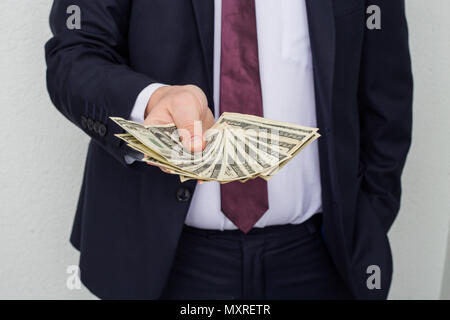 Business Man Displaying a Spread of Cash over a white vintage background Stock Photo