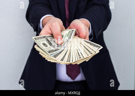 Business Man Displaying a Spread of Cash over a white vintage background Stock Photo