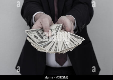 Business Man Displaying a Spread of Cash over a white vintage background Stock Photo