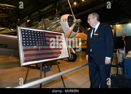 The flag that flew on the USS St. Louis during the Dec. 7, 1941 Japanese surprise attack on Pearl Harbor is on display at the National Museum of the United States Air Force Dec. 7, 2016. The one-time display commemorates the 75th anniversary of the 'Day that will live in Infamy,' which ushered the United States participation into World War II. Looking upon the display is museum volunteer Del Johnson whose father, U.S. Navy Fireman 2nd Class John Johnson, manned a machine gun at Pearl Harbor sub base on that fateful morning. (U.S. Air Force photo by Al Bright) Stock Photo