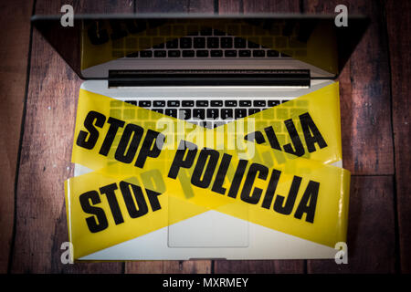 Found evidence of a criminal offense in the laptop, the police secured a laptop tape, and wanted to collect information from it, a laptop and a police Stock Photo