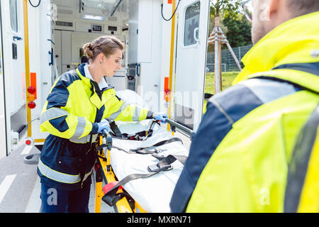 Paramedics preparing stretcher at ambulance Stock Photo