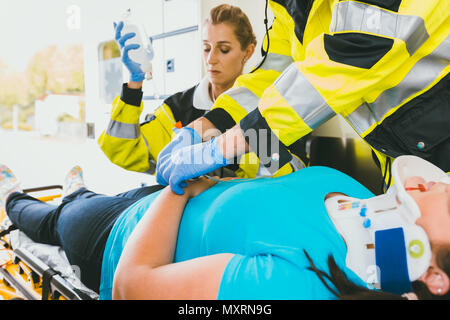 Medics with injured woman giving an infusion Stock Photo