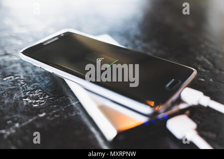 Bangkok, Thailand - May 24, 2018: Samsung Galaxy S7 Edge smartphone charging power via powerbank battery charger. Illustrative editorial image. Stock Photo