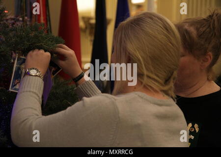 Gold star family attendees hang an ornament on the Gold Star Families Christmas tree in memory of their loved one who gave the ultimate sacrifice during the Global War on Terrorism at the State Capitol building in Denver, Colo., Dec. 7, 2016. The Gold Star Families Reception event recognizes military members from Colorado who gave their lives in the Global War on Terrorism since Sept. 11, 2001. (U.S. Army National Guard Photo by Sgt. Ray Casares/ Released) Stock Photo