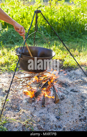 Cauldron or camping kettle over open fire outdoors Stock Photo - Alamy