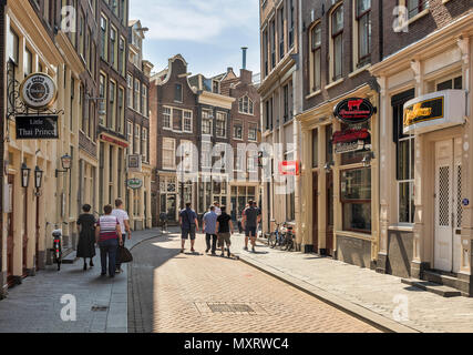 AMSTERDAM, NETHERLANDS - MAY 27: (EDITORS NOTE: Image has been digitally enhanced.) Only several tourists walk on the Zeedijk Street at the Red Light District on May 27, 2018 in Amsterdam, Netherlands. The life is used to start after sunset in this interesting part of the city. Stock Photo