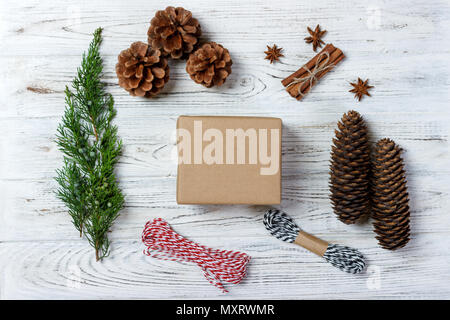 Creative hobby. Gift wrapping. Packaging modern christmas present boxes in stylish gray paper with satin red ribbon. Top view wood table with fir tree Stock Photo