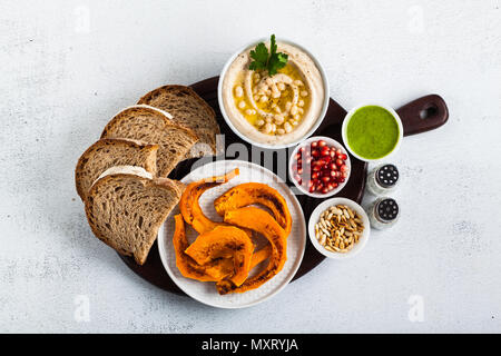 vegan appetizer snack from hummus of white cannellini beans and baked pumpkin with Rye bread on a serving board. Just great food Stock Photo